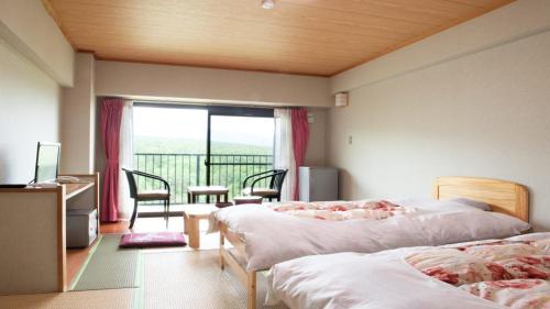草津新柯约酒店的酒店客房设有两张床和一个阳台。