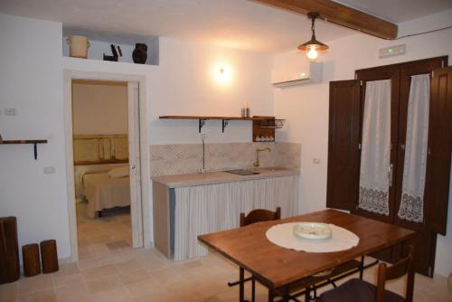 卡斯特拉纳格罗泰Trulli don Pietro的厨房以及带桌子和水槽的用餐室