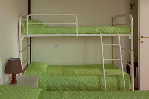 滨海库普拉La casa de Rocche的一间卧室配有两张双层床,铺有绿色床单。
