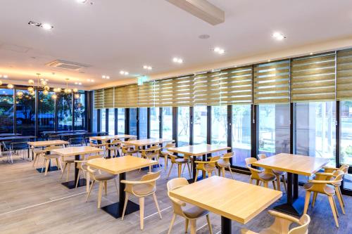 西归浦市Shin Shin Hotel Seogwipo的餐厅设有桌椅和窗户。
