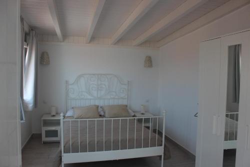莫罗德哈布雷Villa coralin的一间白色卧室,在房间内配有一张婴儿床