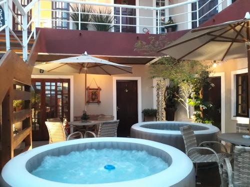 纳韦甘蒂斯Navega Apart Hotel的庭院设有热水浴池,配有桌椅