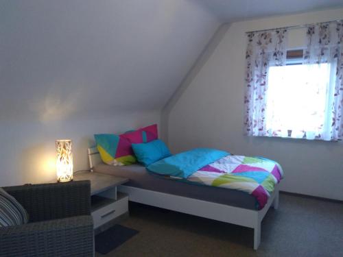 BaiersdorfScharfs Kämmerla的一间卧室配有一张带色彩缤纷枕头的床和窗户。