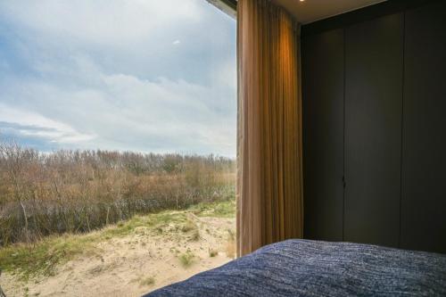 泽布吕赫Penthouse La Naturale zeezicht的一间卧室设有窗户,享有海滩美景