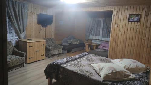 沃罗赫塔Sadyba Geredzhuka的一间卧室配有一张床、一把椅子和电视。