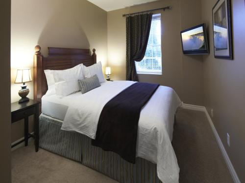 滨湖尼亚加拉格里夫斯甜蜜隐遁公寓的一间卧室设有一张大床和一个窗户。