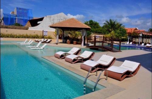 拉巴拉德纳圣米格尔Barra Bali Apartamento 06 - Paraíso à Beira Mar的一个带躺椅和凉亭的游泳池