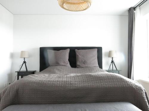 哥本哈根ApartmentInCopenhagen Apartment 1187的一间卧室配有一张大床和两盏灯。
