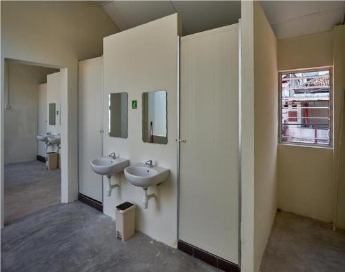 乔治市We Love GuestHouse的浴室设有2个水槽和2面镜子