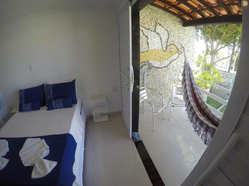 马拉戈日Chalé 4, Maragogi, Condominio Village Galés的一间卧室配有一张床,阳台配有绘画作品