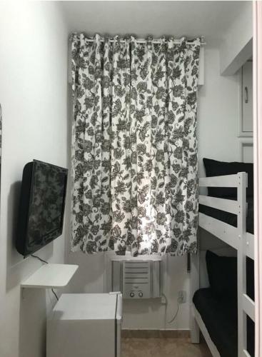 里约热内卢Quarto Leme的一间卧室配有窗帘和一张双层床。