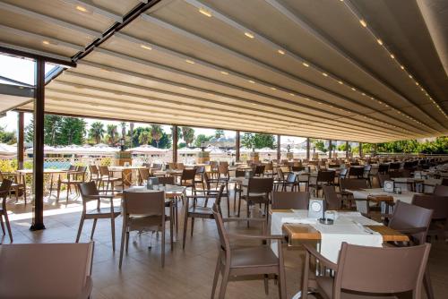锡德Side Star Resort Hotel - Ultra All Inclusive的一间设有白色桌椅和窗户的餐厅