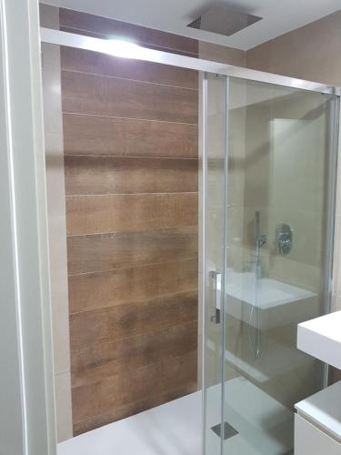 贝尼多姆ROMERO APARTMENTS-SUNSET WAVES-BENIDORM的带淋浴的浴室和玻璃门
