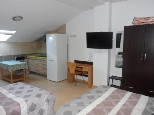 MadrigalejoHostal Via Del Caminante的一间卧室配有一张床、一张书桌和一台电视。