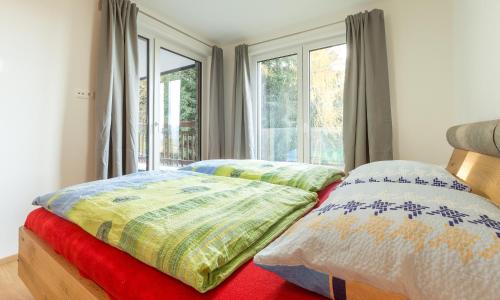 斯拉德明Ski In Ski Out Apartment Fastenberg Top 2 by AA Holiday Homes的一间卧室设有两张床和窗户。