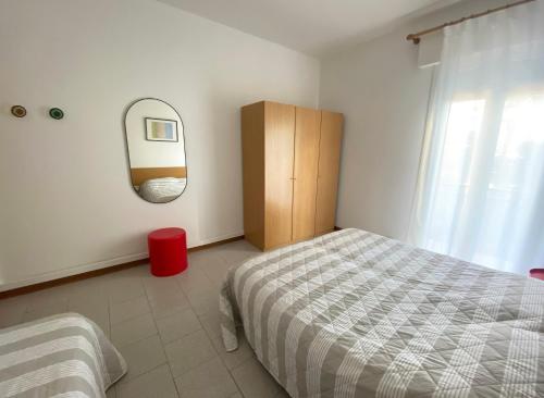 利多迪耶索罗Dainese Apartments, Casa Ester的卧室配有一张床,墙上设有镜子