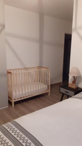 Le BarrouxEvadorie的一间卧室配有婴儿床和带台灯的桌子