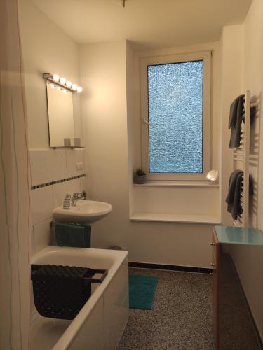 汉诺威菲罗所费维尔特尔公寓的带浴缸、水槽和窗户的浴室