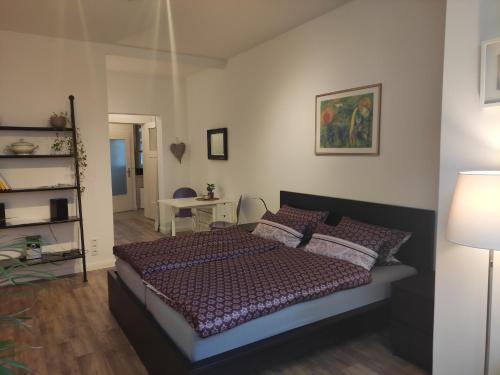 汉诺威菲罗所费维尔特尔公寓的一间卧室配有一张床、一张桌子和一盏灯
