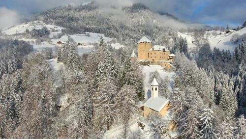上韦拉赫蕾娜切尔霍芬酒店的山中白雪覆盖的房子的空中景色