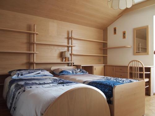 博萨迪法萨Ciasa Giorgina的配有木墙和架子的客房内的两张床