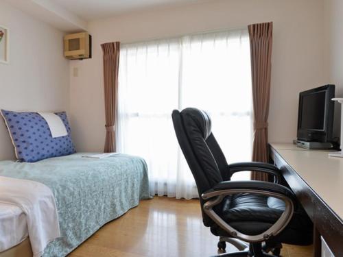 札幌札幌克拉克酒店的一间卧室配有书桌、椅子和床