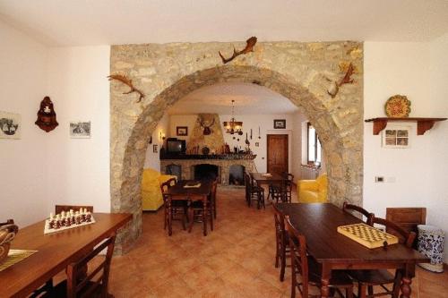特拉西梅诺湖畔帕西尼亚诺阿格里图里斯莫玛提斯别墅酒店的客厅设有拱门,配有桌椅