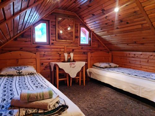 布朗Pensiunea Neba的小木屋内一间卧室配有两张床和一张桌子
