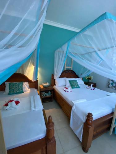 肯杜瓦Pumzika Kendwa Villa的蓝色墙壁客房的两张床
