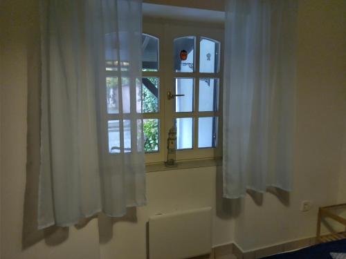 雷夫菲勒普Sirály Apartman的窗户,有白色窗帘