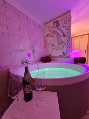 大格洛克纳山麓卡尔斯美恩斯度假屋的一间带浴缸及两杯葡萄酒的浴室