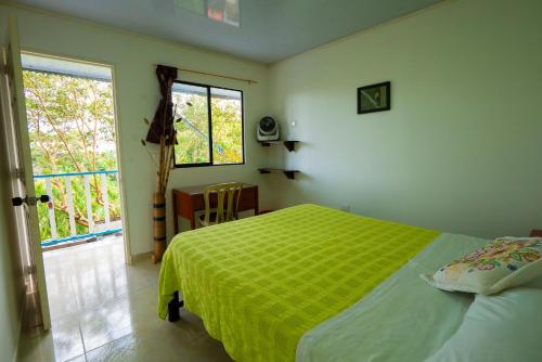 亚美尼亚Casa Campesina Hostel的一间卧室设有一张绿色的床和一个窗户。