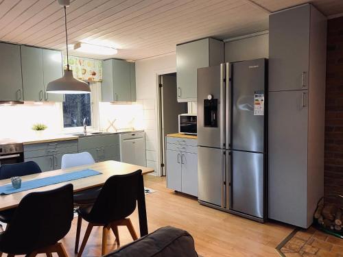 韦特兰达Nommen Fishing Cottages的厨房配有桌子和不锈钢冰箱。