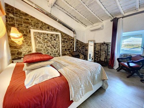 马林堡Monte Do Malhao - Art, Eco & Spa的一间卧室设有一张床和石墙