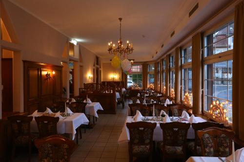 萨兰德特Parkhotel Forsthaus的一间带桌椅和吊灯的餐厅