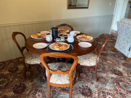 史丹霍普Big Fella Wines & Accommodation的一张木桌,上面放着食物盘