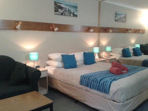 卧龙岗爱索诺汽车旅馆的一间卧室配有两张带蓝色和红色枕头的床