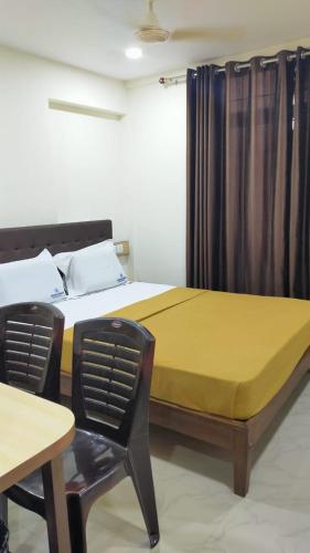 门格洛尔Bhumi Residency的一间卧室配有一张床、一把椅子和一张桌子