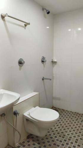 门格洛尔Bhumi Residency的白色的浴室设有卫生间和水槽。