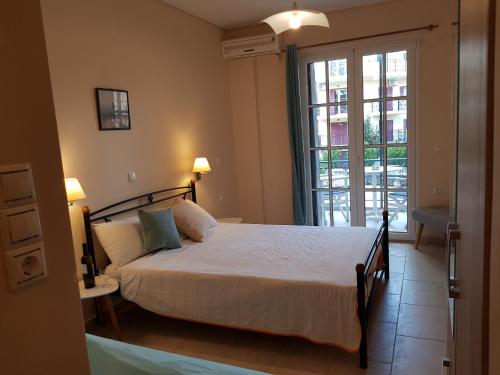 瓦西利基Nefeli的一间卧室设有一张床和一个大窗户