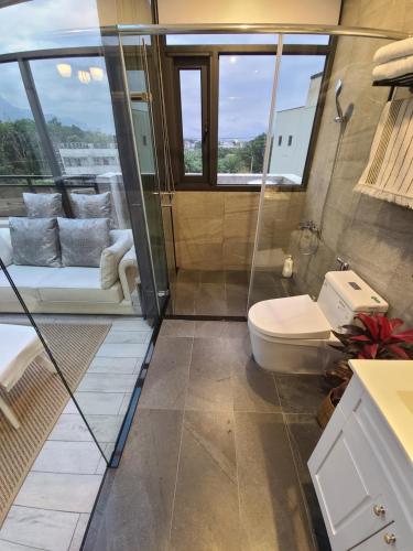 Shunan如果玉見你景觀民宿的一间带卫生间和玻璃淋浴间的浴室
