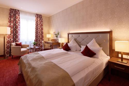 慕尼黑索彻利克肯酒店的酒店客房配有一张带红色枕头的大型白色床。