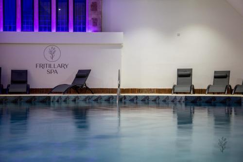 克里克莱德克里克拉德之家酒店 - 贝斯特韦斯特必住签署系列酒店的游泳池旁的一排椅子