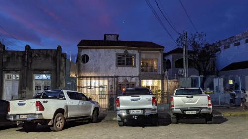 科伦巴Pousada Corumba Center的停在房子前面的三辆卡车