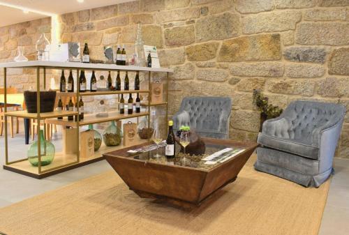 奥伦塞Gandarela Turismo Rural的一间设有两把椅子和一张带葡萄酒的桌子的房间
