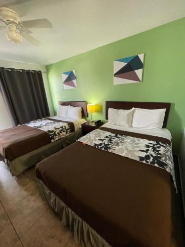拉雷多Hwy 59 Motel Laredo Medical Center的绿墙旅馆客房的两张床