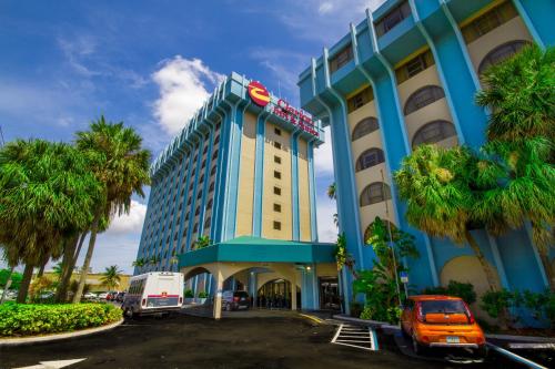迈阿密迈阿密国际机场克拉里奥套房酒店的拥有蓝色建筑和棕榈树的酒店