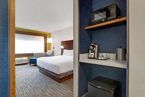 金斯顿Holiday Inn Express - Kingston West, an IHG Hotel的酒店客房带一张床和一台微波炉