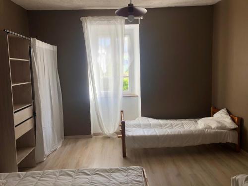 德沃吕伊Maison campagne au col du festre的一间卧室设有两张床和窗户。