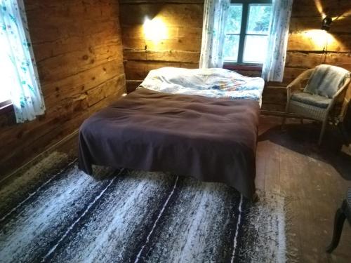 TornimäePaali cottages的一间卧室配有一张床、一把椅子和窗户。